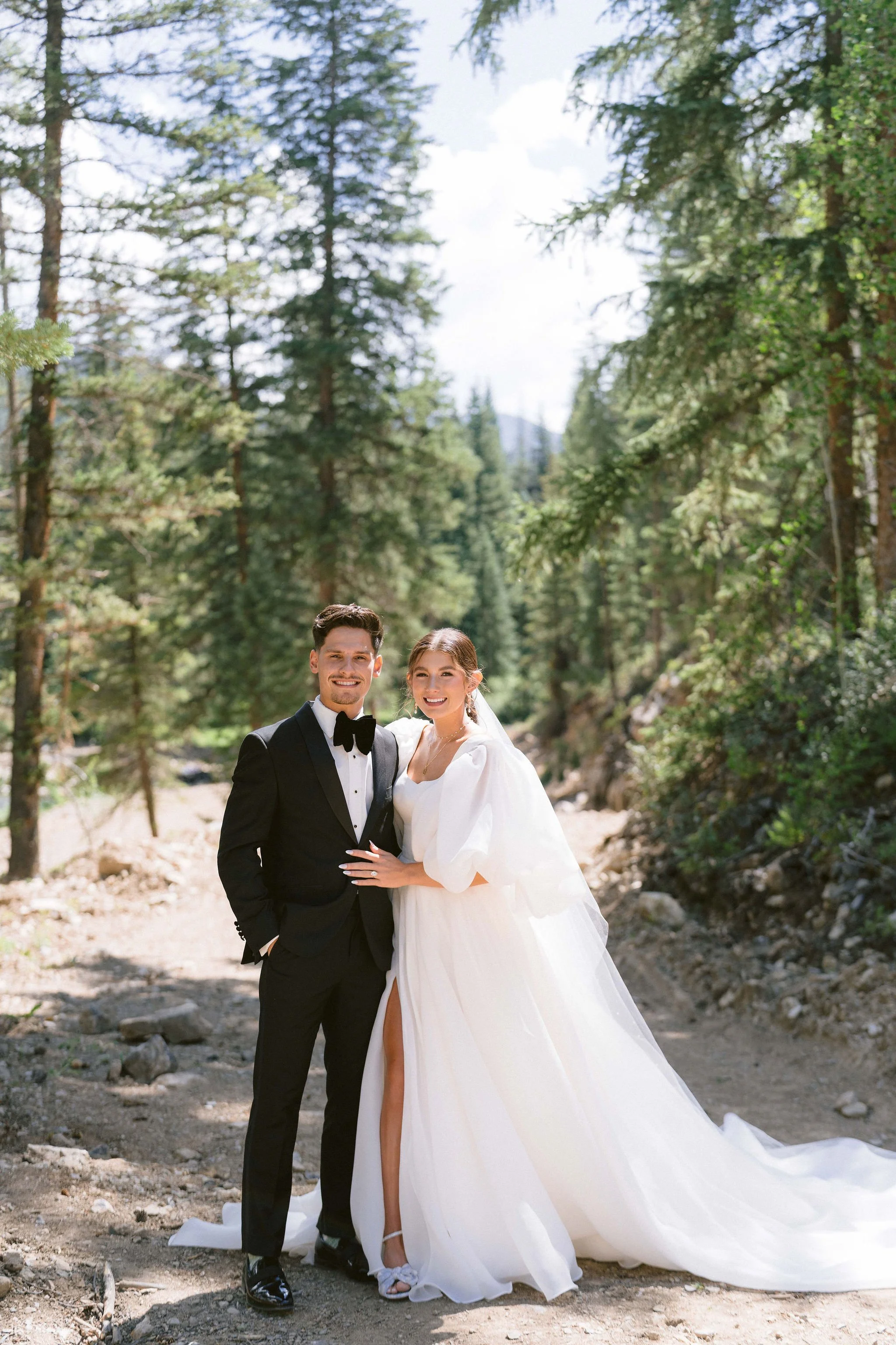 portrait in front of the mountains with pine trees of bride and groom