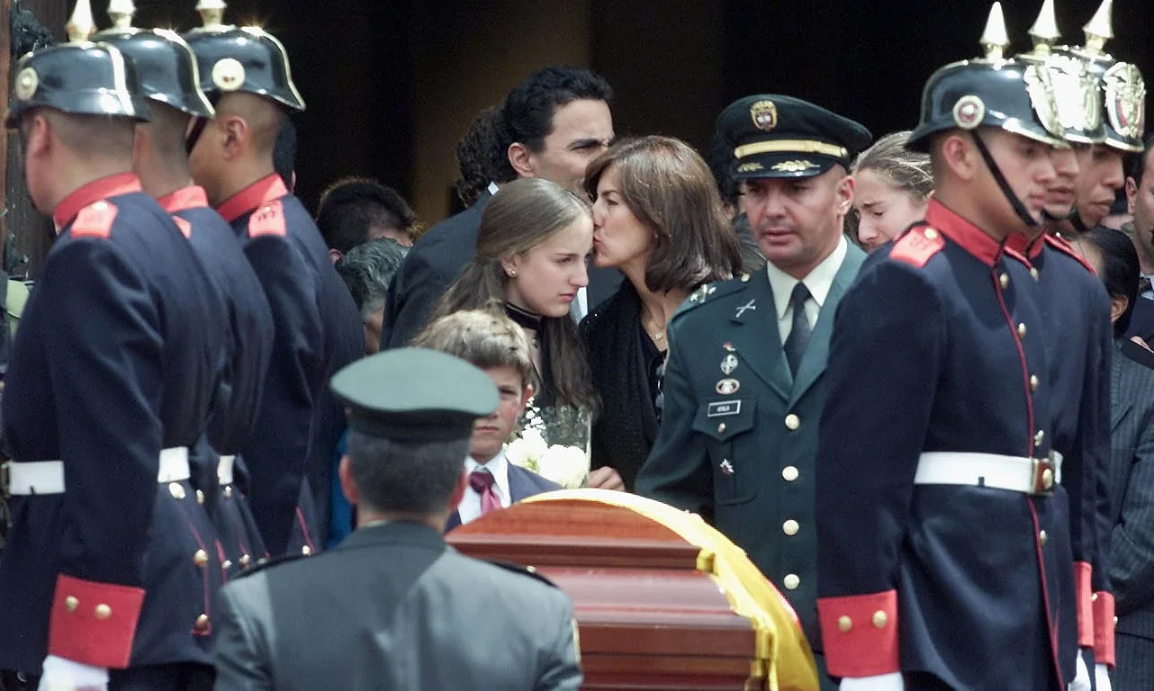 Maria Zulema Velez, the wife of the minister of social welfare, Juan Luis Londono, kisses her older daughter Juliana as they leave Bogota's cathedral after a funeral mass. Londono, three advisers and a pilot died in a plane crash, 2003.