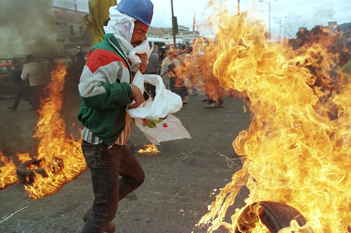 A man lights tires during a demonstration trying to overturn a mayoral order to clear out the city center's homeless population, 1999.