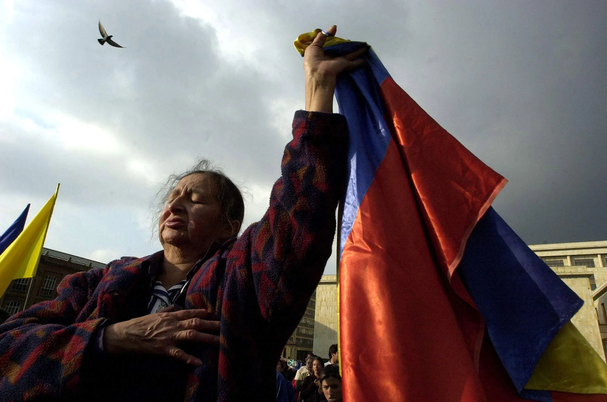 A woman holds a Colombian flag during a moment of silence in Bogota, Colombia, 2002. 
