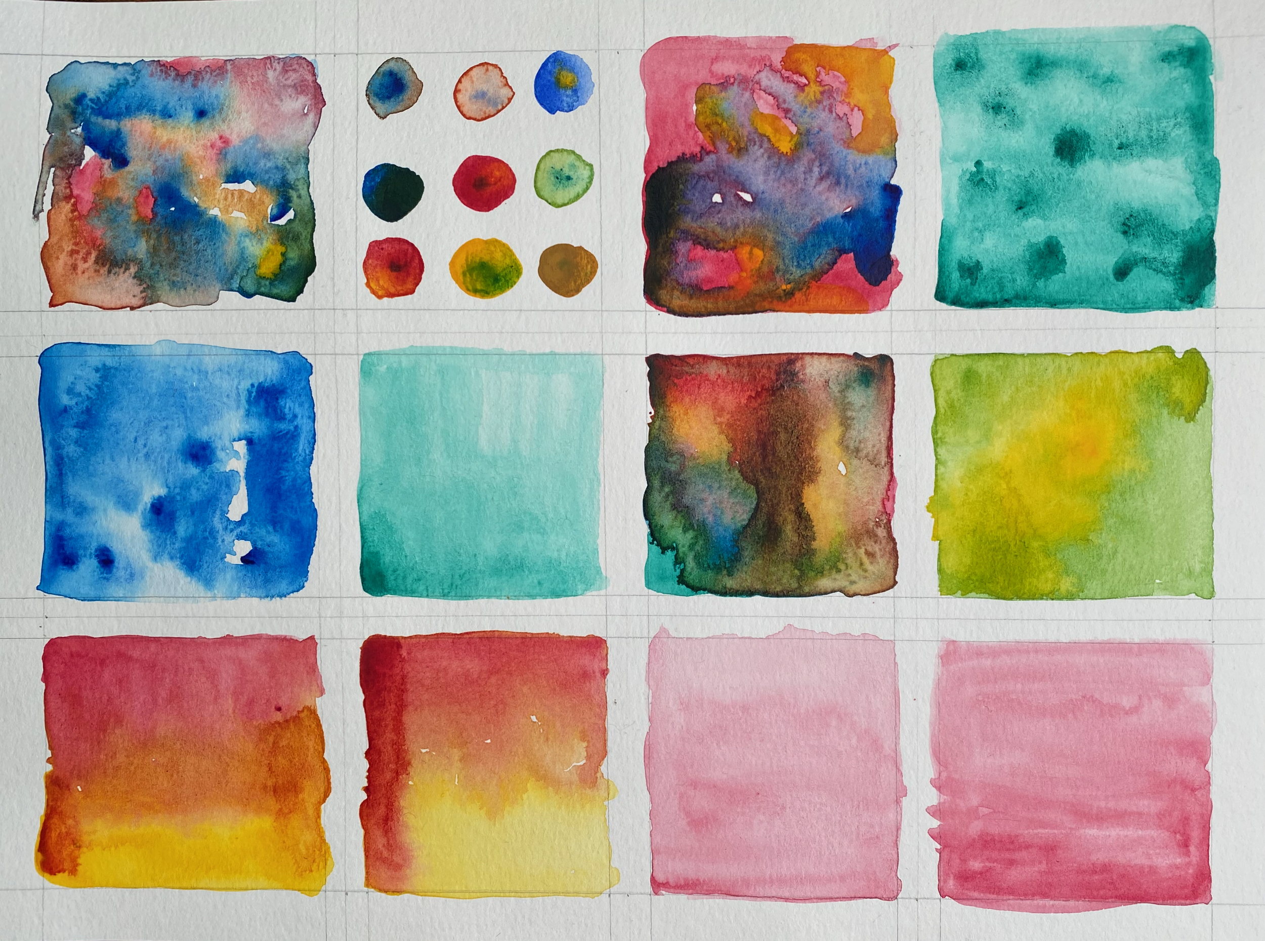 A collection of watercolor swatches and paint samples on cold press paper, including squares and circles in various colors such as blue, red, orange, yellow, green, and purple.