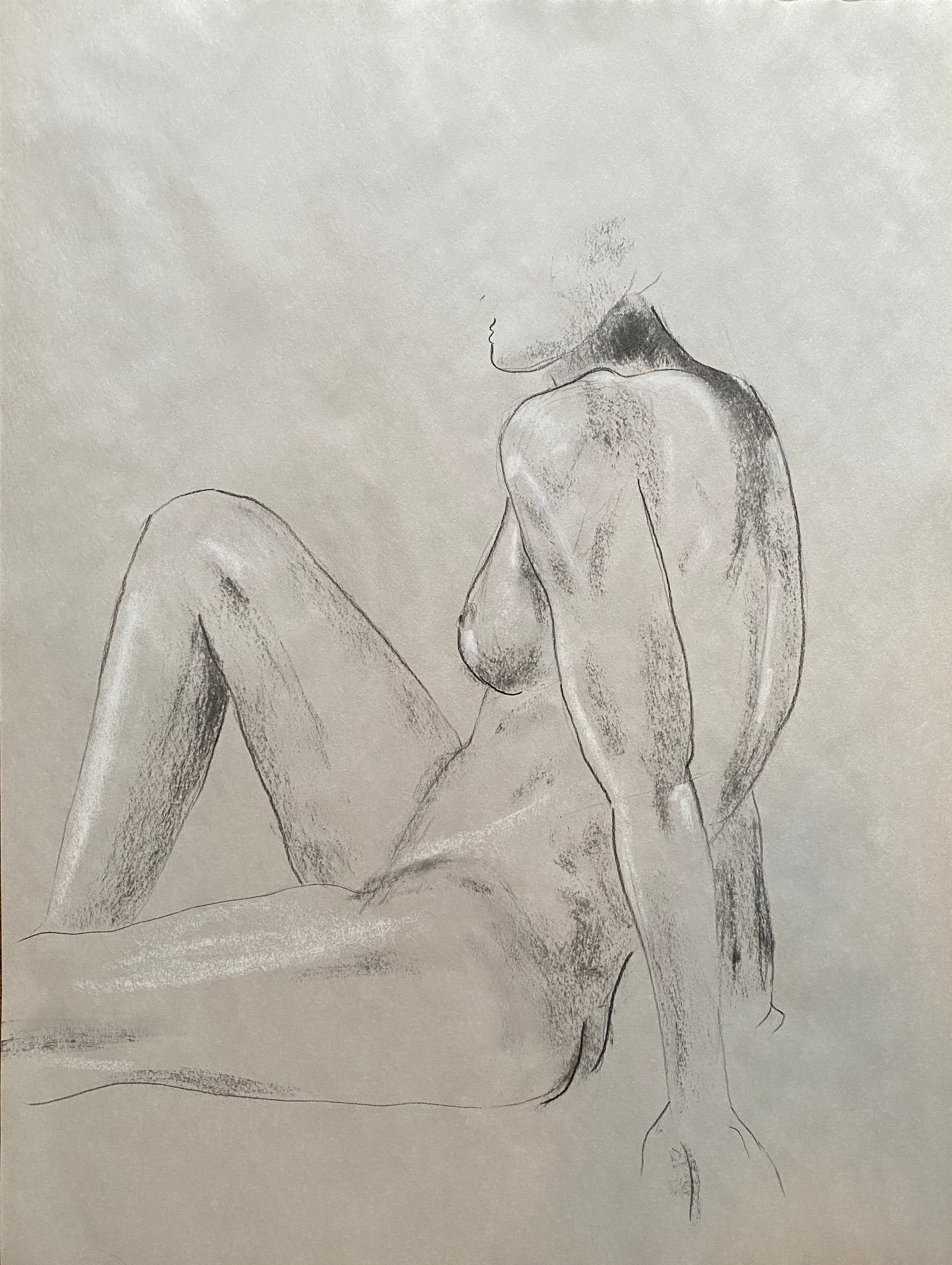 Charcoal sketch of a nude woman seated with her right leg bent and foot flat on the surface, and her left leg extended downward. Her face is turned to the side, with her chin slightly raised. Soft shading highlights her body contours.