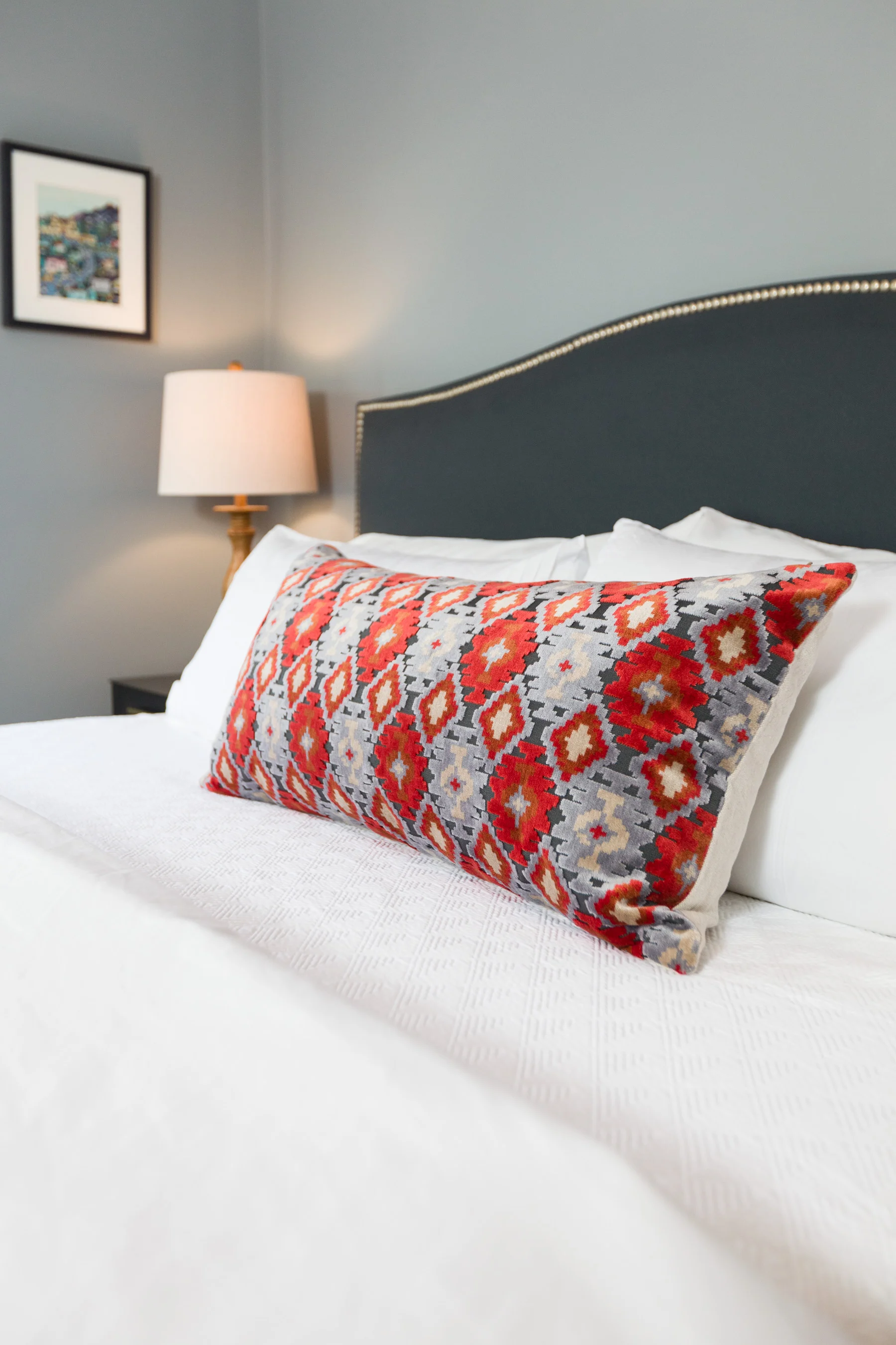 A custom velvet and linen pillow anchors the master bedroom.