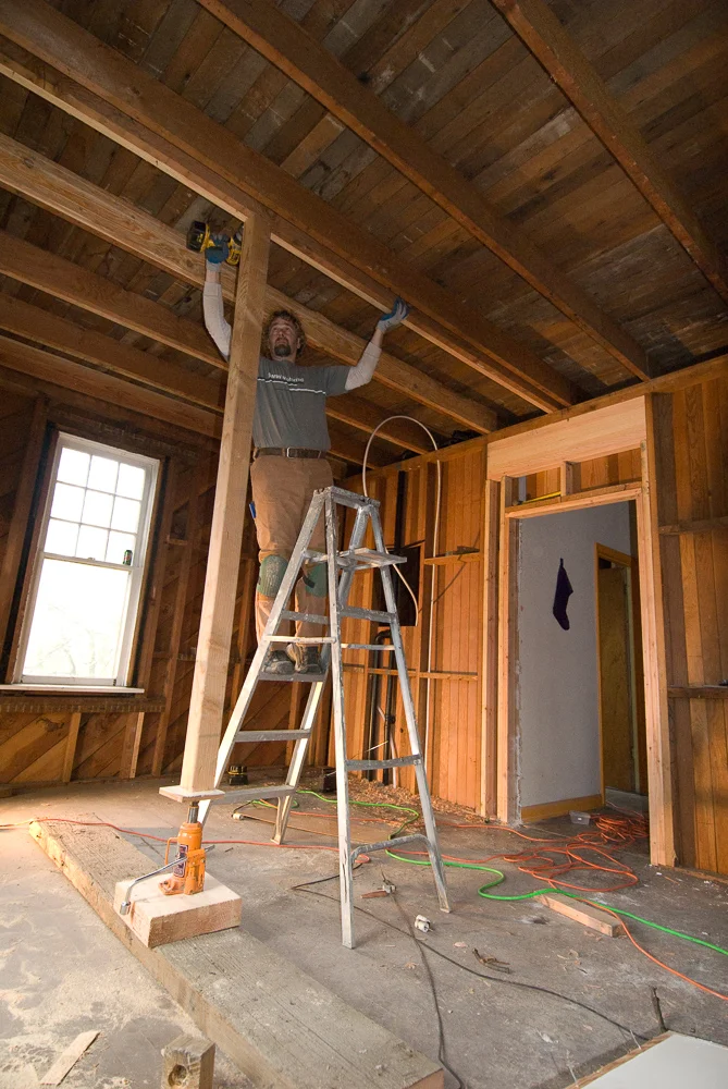 Doubling the floor joists to reinforce. Each new joist had to be ripped to match the old dimensional wood.