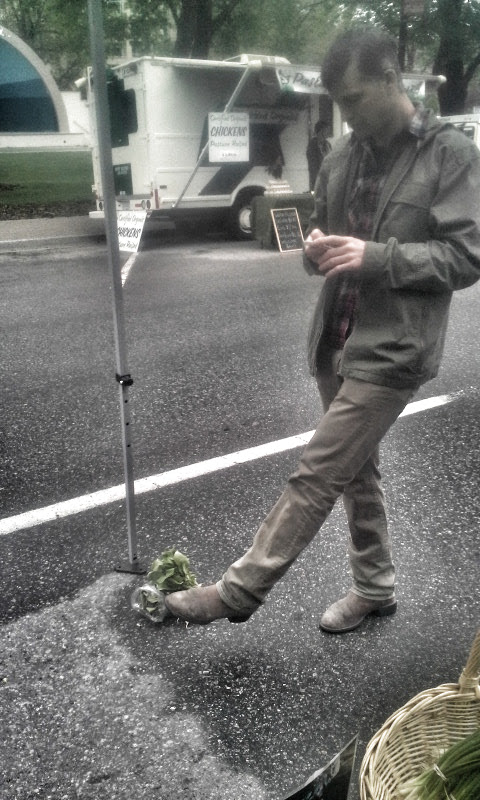   Tyler Harlton of TH Wines puts his Homestead Produce on the street to play with his phone. "It's okay," he said. "I've got a good immune system."  