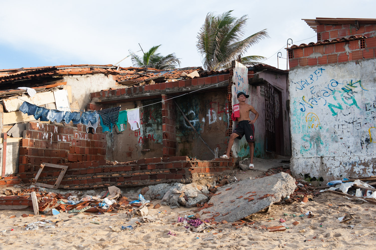 A young man stands outside his home in the beachside City of Fortaleza, Brazil. Fortaleza is one of several cities to host the 2014 World Cup and the 2016 Olympics. As the excitement for the World Cup builds, Fortaleza's favela (slum) residents grow…