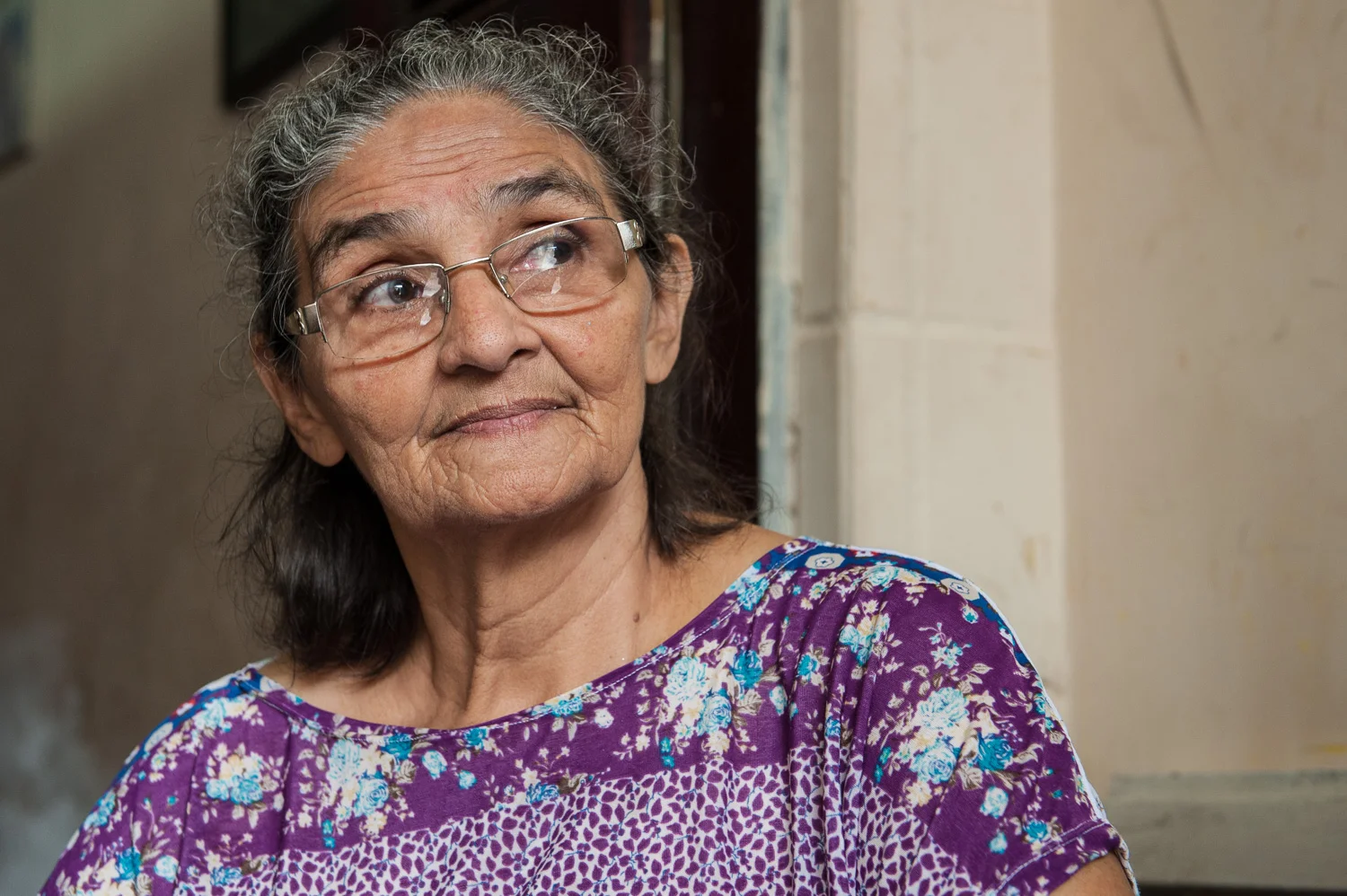 Yope Maria, a resident of the favela Poco da Draga since 1961, has raised her 10 children, 14 grandchildren, and now a great grandchild there. Now, she and her neighbors fear they will be evicted to create a parking lot for a new acquarium. She is confident that she is a legal owner but has little hope of compensation or resettlement.