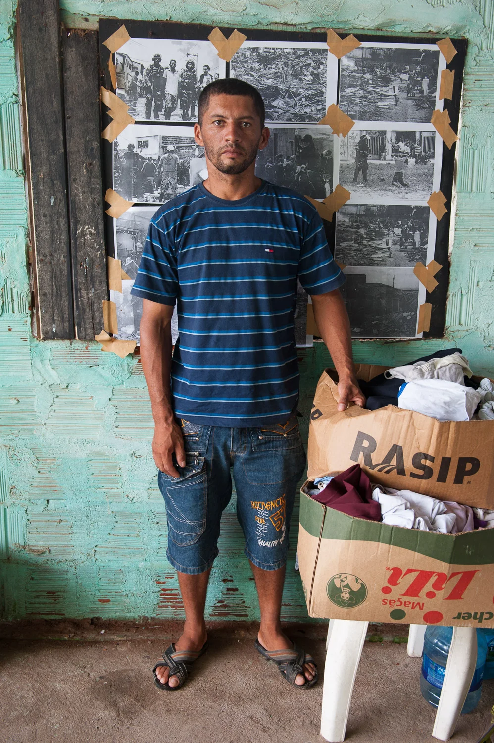 In February 2014, Jean Paulo Teixeina Silva and his family were forcibly evicted – without notice – from his home in the favela (slum) of Alto da Paz in Fortaleza, Brazil. Now homeless, he stands with the only belongings he could carry in front of images of the violent eviction.
