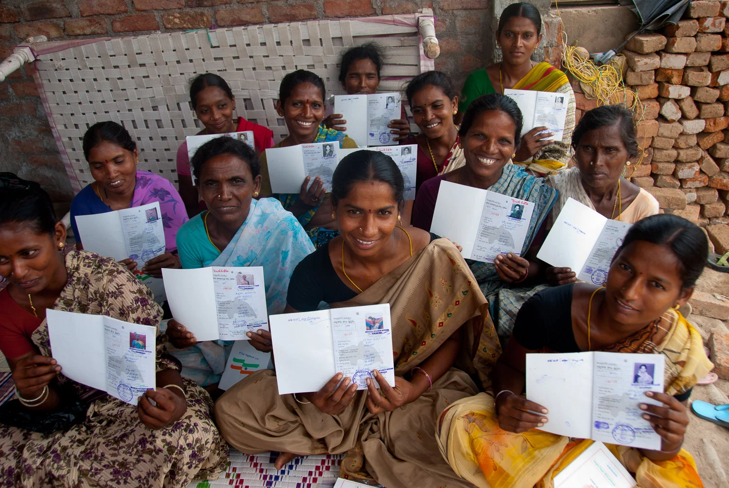 in Andhra Pradesh, India, a group of formerly landless women display their new pattas (titles) showing that each owns one acre of land. The women had participated in a World Bank Land Purchase Program, which subsidized the purchase of land on the open market for landless women. The project required that the land be registered in the name of the woman only. 