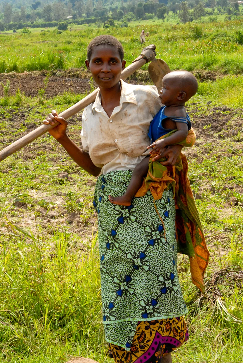 Consolata, with her son in tow, farm land that they lease from the government. 