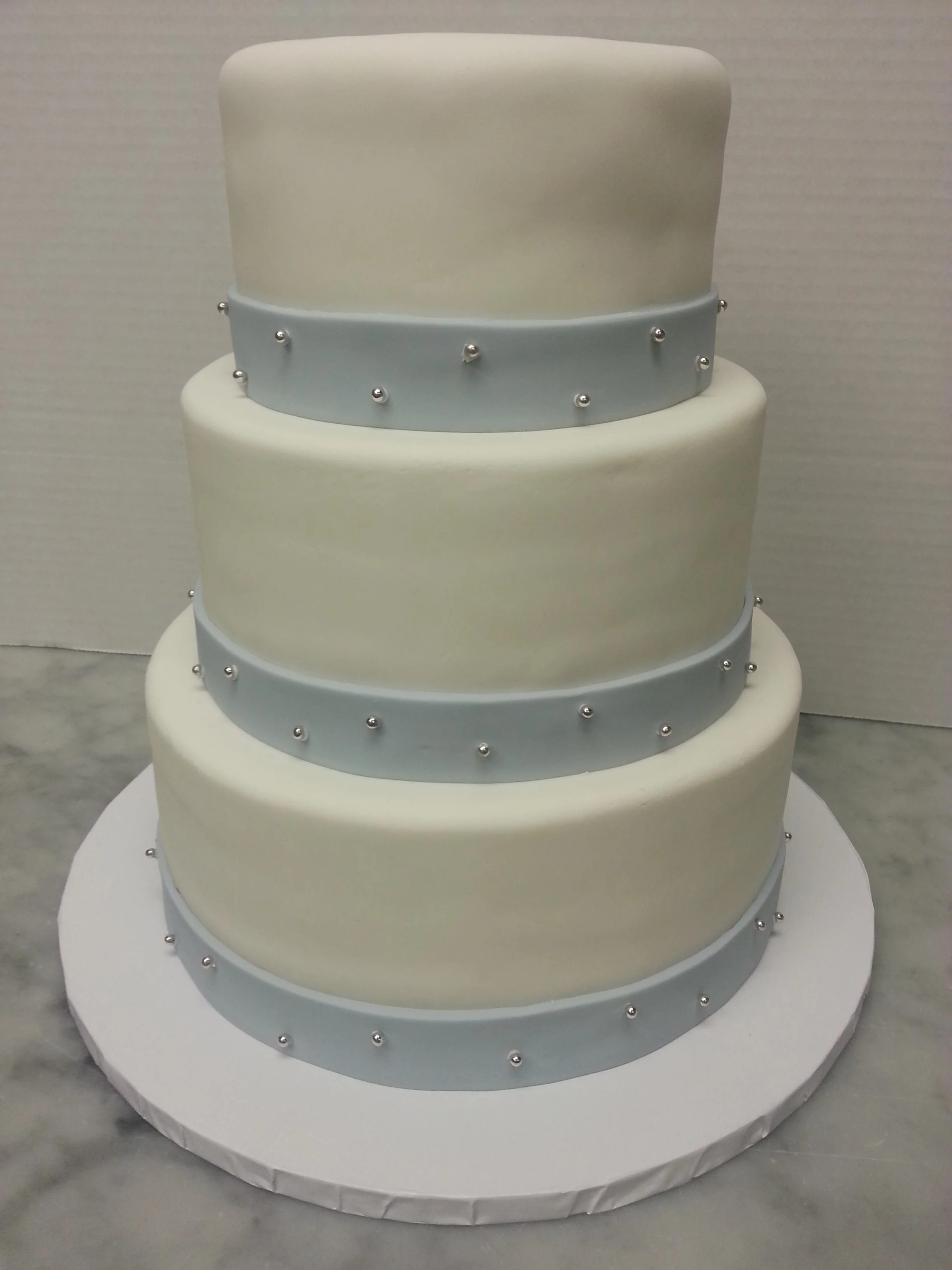 wed cake with powder blue band and dragees.jpg