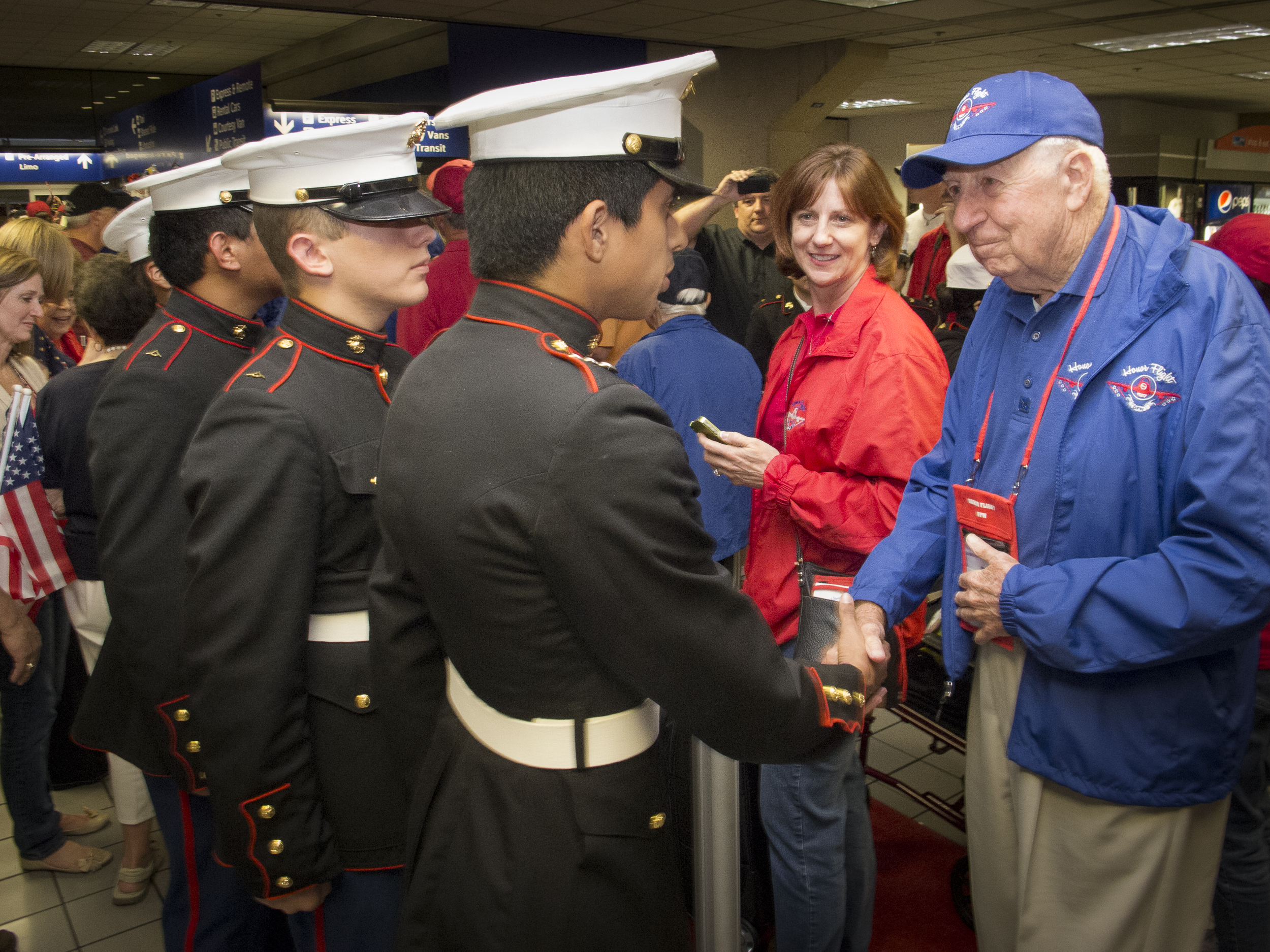 Honor Flight participant and WWII verteran, Captain Bill J Baker (Ret.) receives congratulations from young Marines at his return from the Washington, DC trip and tour. Copyright © Kipp Baker, All rights reserved.
