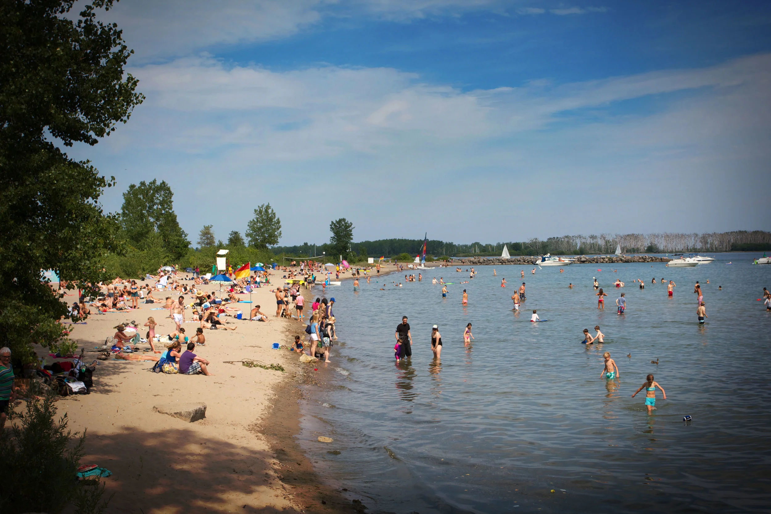 Torontonians embracing Ward's Island Beach. (Photo via Lake Ontario Waterkeeper)
