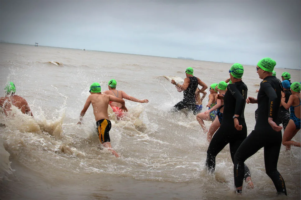 Swimmers bounding into Lake Erie's chilly waters for the North Shore Challenge. (Photo via Lake Ontario Waterkeeper)