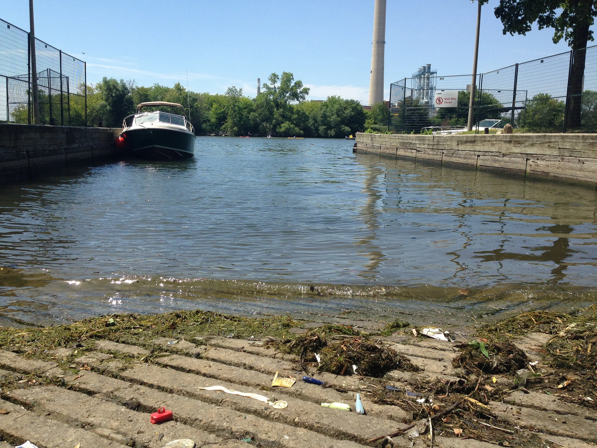 Sewage debris (such as condoms and tampon applicators) found at a boat launch. The smokestack from Ashbridges Wastewater Treatment Facility can be seen in the background. (Photo by Claire Lawson)
