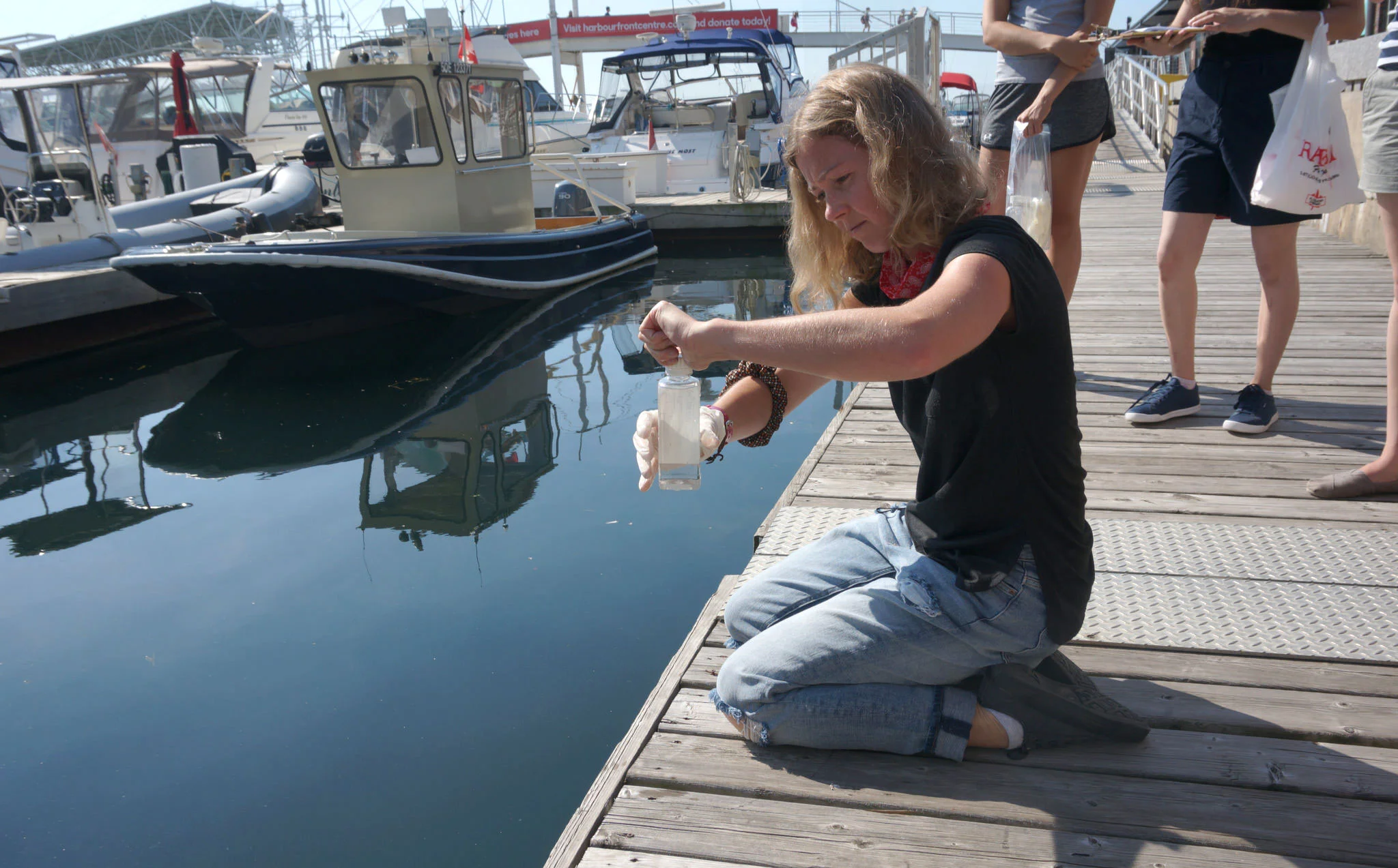 Volunteer, Oksana sampling water from Toronto's Pier 4. (Photo by Lake Ontario Waterkeeper)