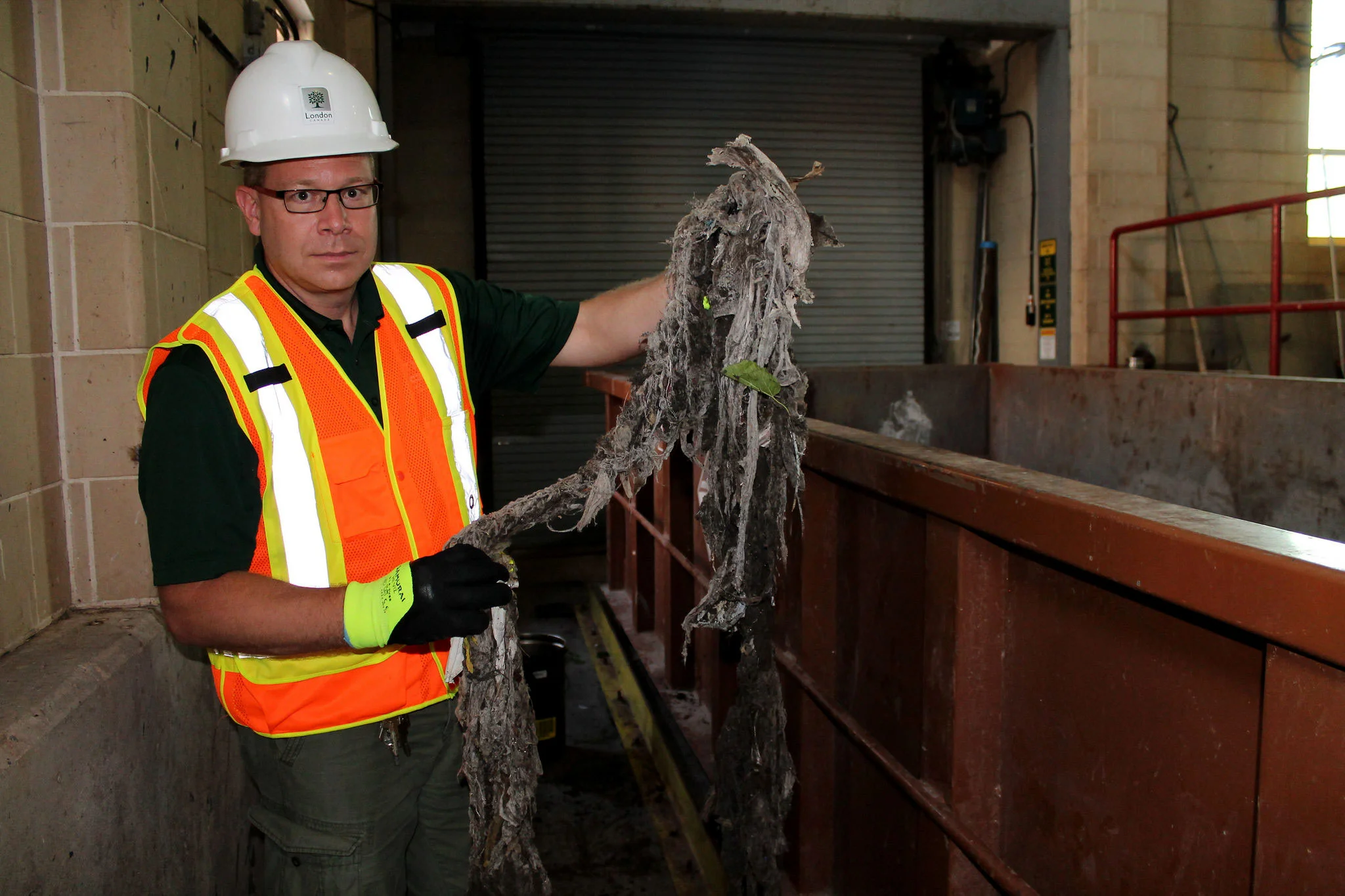 Barry Orr holding up a "rope" of wipes and other non-flushables that were pulled out of wastewater. (Photo by Ruby Pajares)