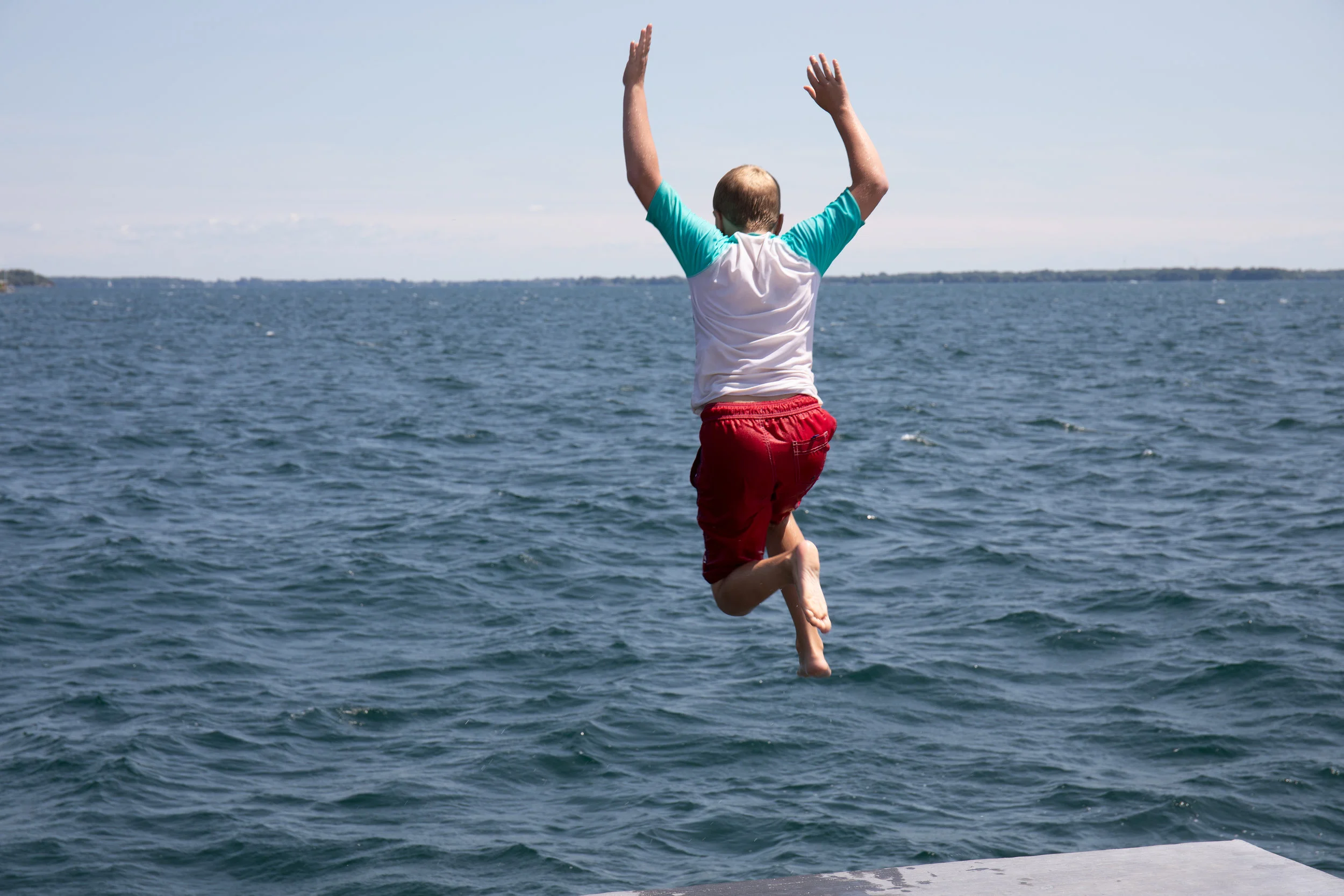Leaping from the Gord Edgar Downie Pier into Lake Ontario. Photo by Swim Drink Fish.