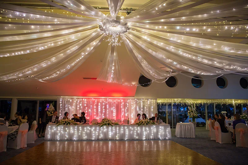 A simple white fabric and fairy light backdrop with coloured lights. The light colour can be changed to suit your colour scheme.