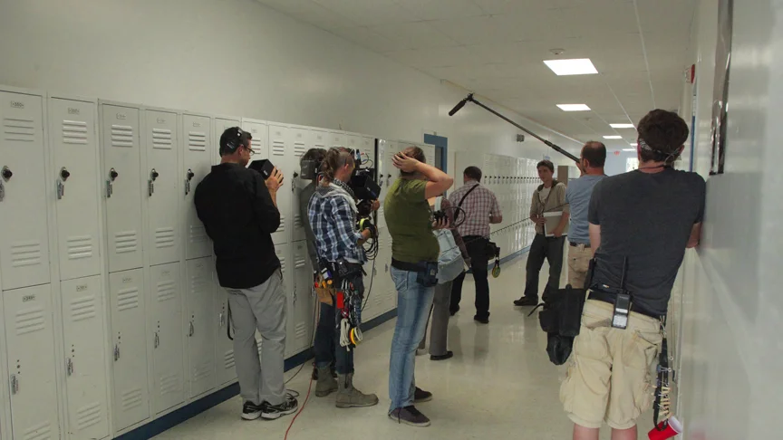 PHOTO CREDIT: Behind-the-scene photo of the crew filming a scene with Callan McAuliffe inside the Van Buren school - photo from the movie’s official website .