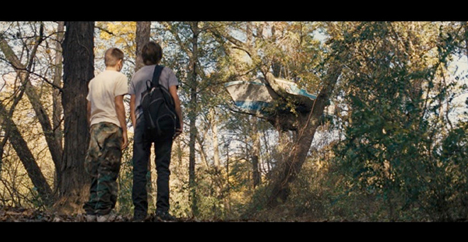 PHOTO CREDIT: Above is a screenshot of Ellis and Neckbone looking up at Mud’s boat-in-a-tree house.
