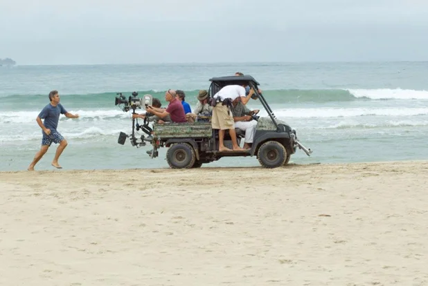 PHOTO CREDIT: A behind-the-scene look of George Clooney (as Matt King) running on the beach by the Hanalei Bay - photo from here .
