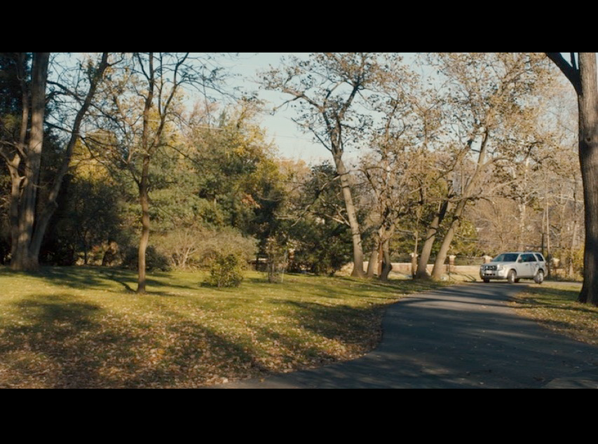 Screenshot of Philomena and Martin driving up the long driveway leading to Peter Olsson's house (the Conways' Potomac house in real life).