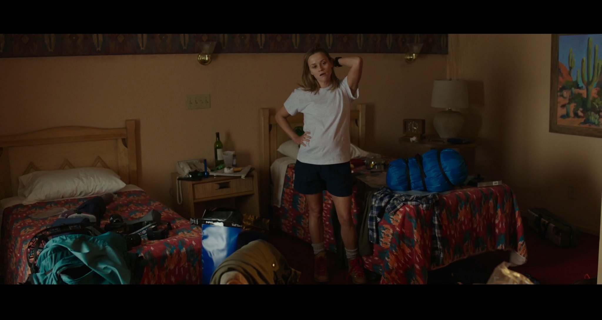 Screenshot of Cheryl (Witherspoon) in a motel room in The Mojave Desert area feeling overwhelmed as she puts her backpack together to get ready for the PCT hike. Filmed on location at the Courtesy Inn Motel in Portland, Oregon.