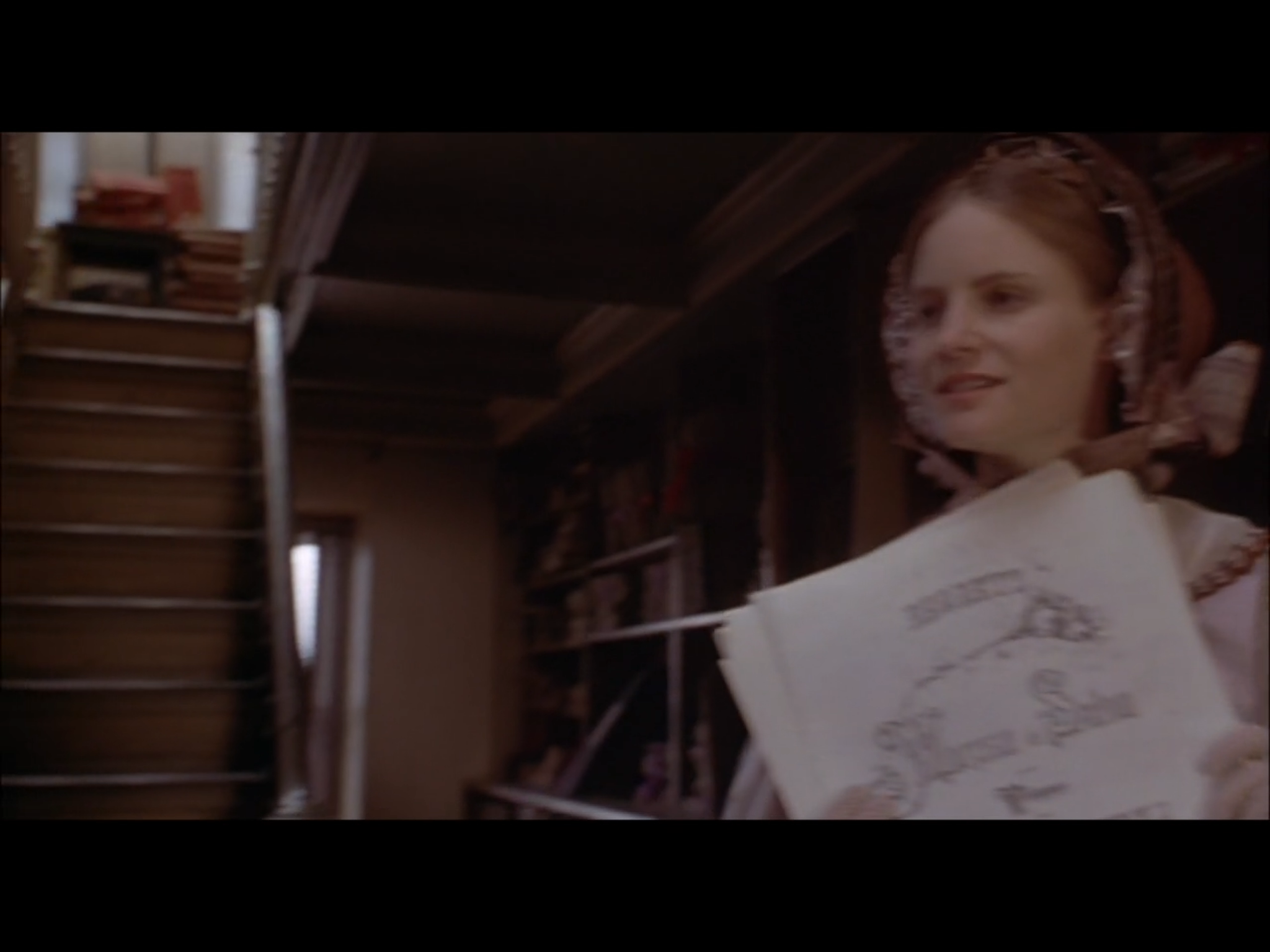 Screenshot from Washington Square of Catherine Sloper (Jennifer Jason Leigh) in a Paris bookshop. This scene was filmed in the George Peabody Library by the stairs leading up to the book stacks above.