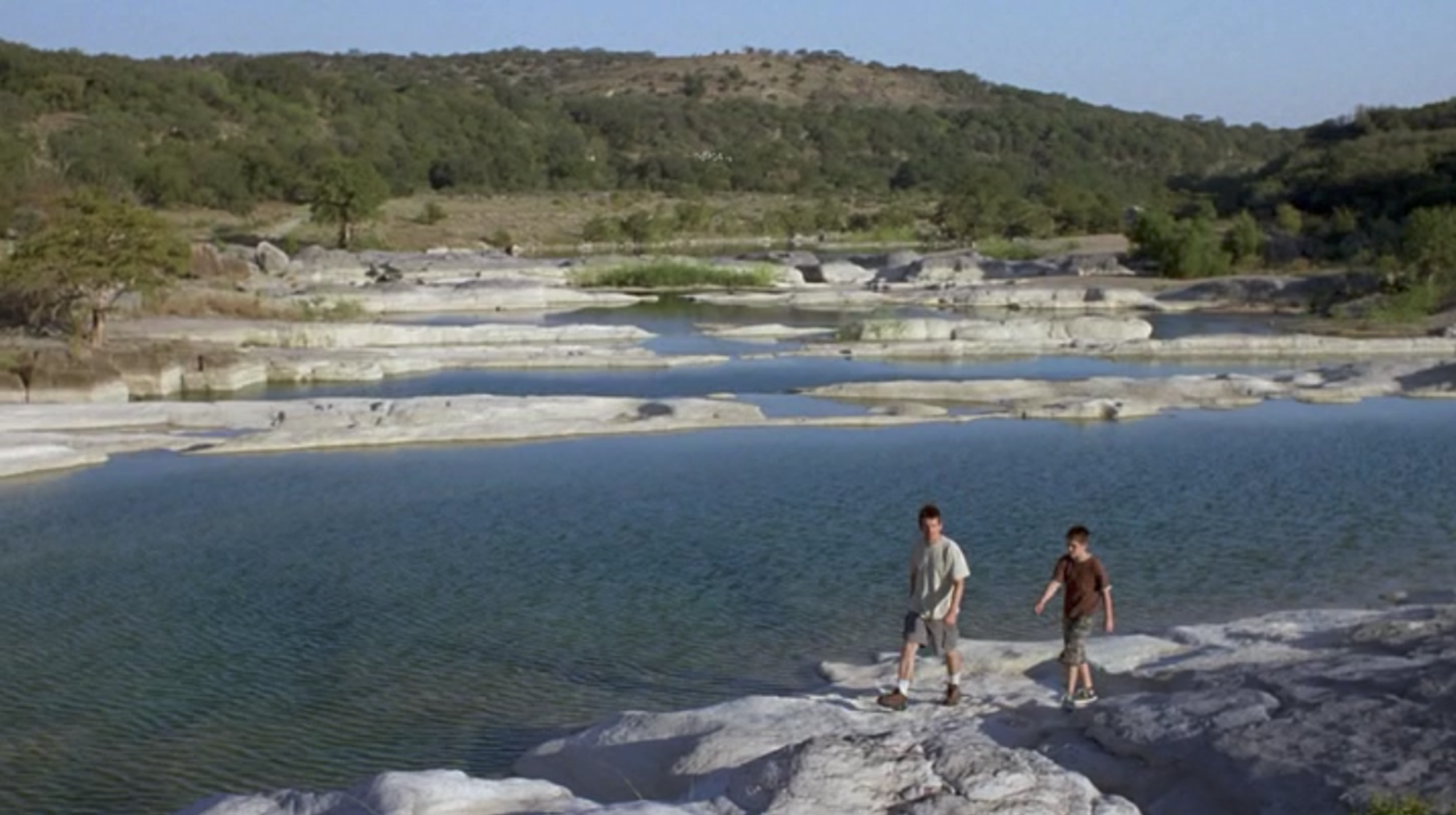 Screenshot from Boyhood of a scene filmed at Pedernales Falls State Park with Mason Sr. and Mason Jr. as they go on a hike in the park.