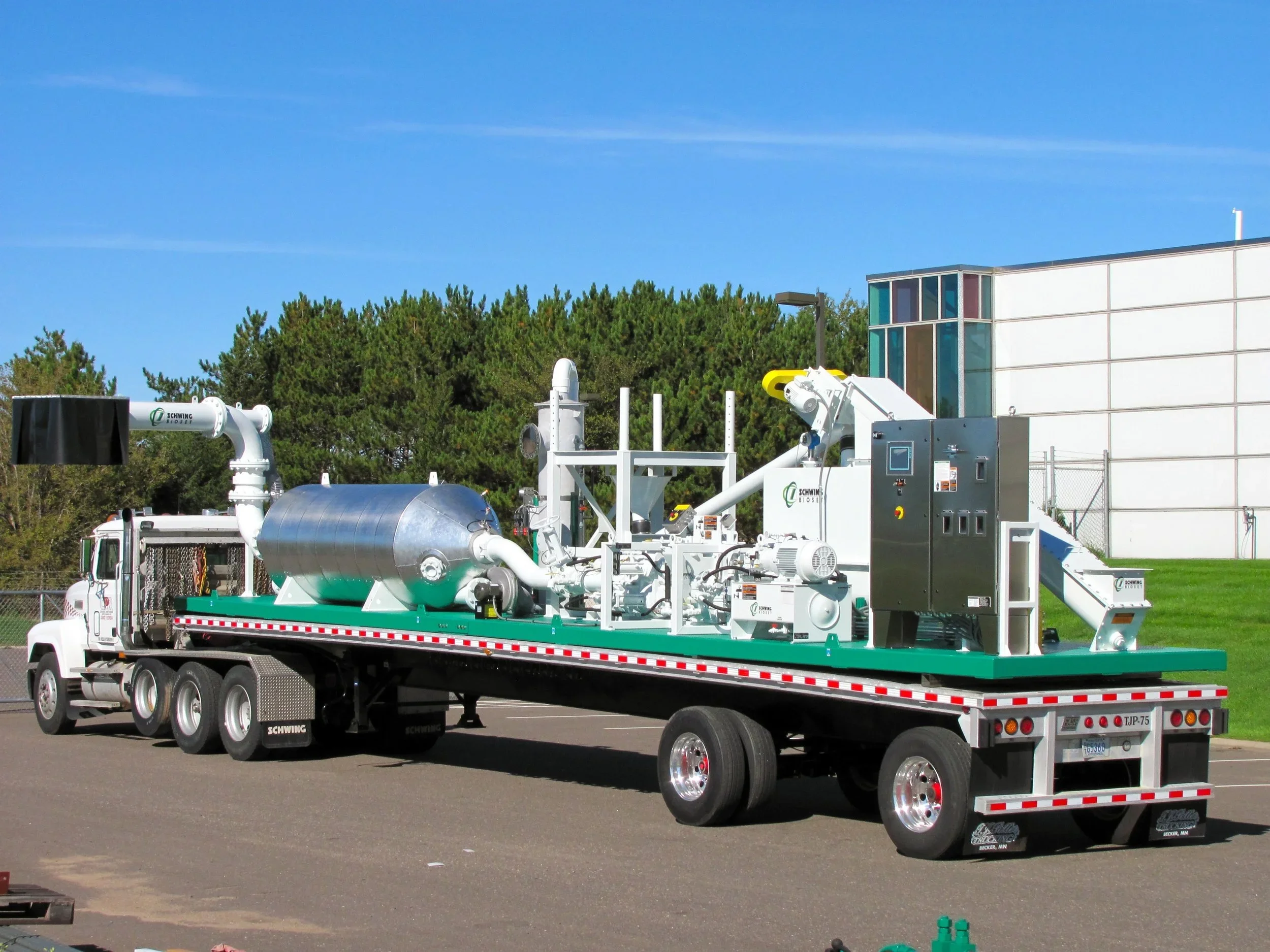 Schwing Bioset Mobile bioset unit on trailer in a sunny parking lot.