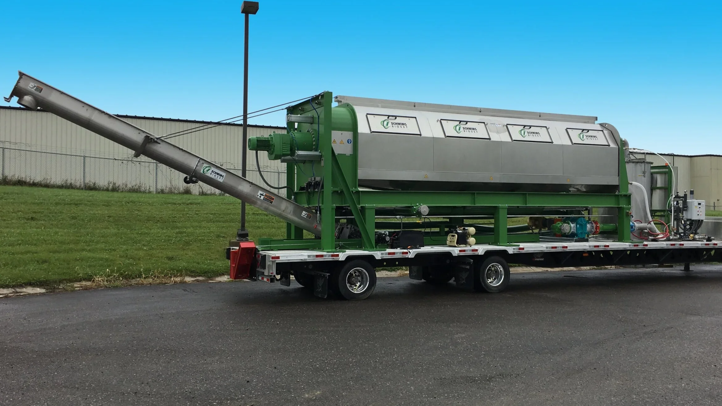 Schwing Bioset screw press in parking lot blue sky