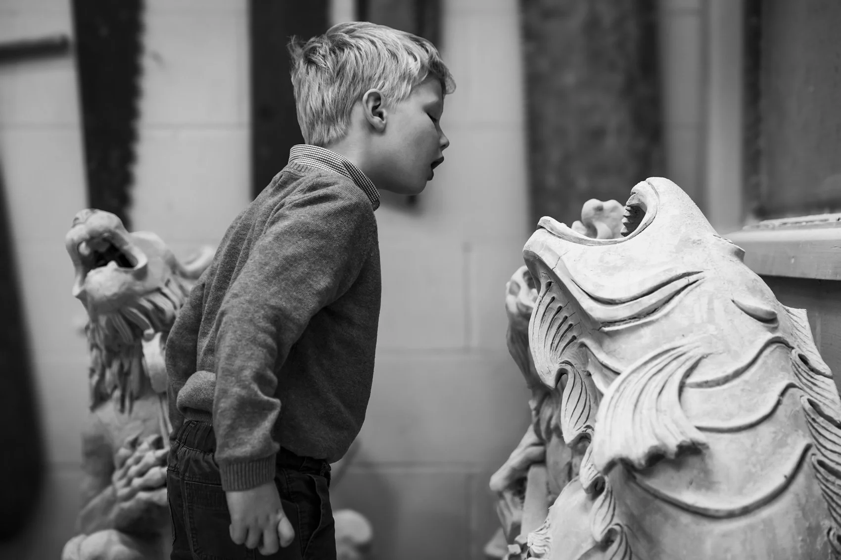 South east brand and reportage photographer,  child, boy, peering at sculpture,