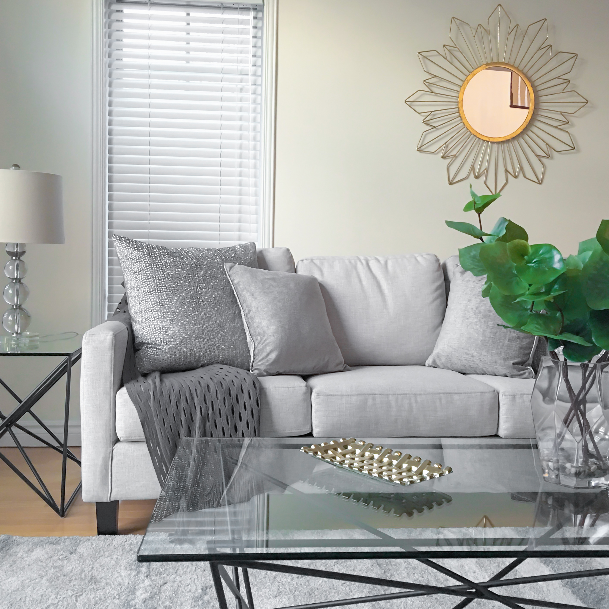 Home Staging provided by New Leaf Decor of living room in Barrie-Neutral furniture accented by warm gold and greenery.