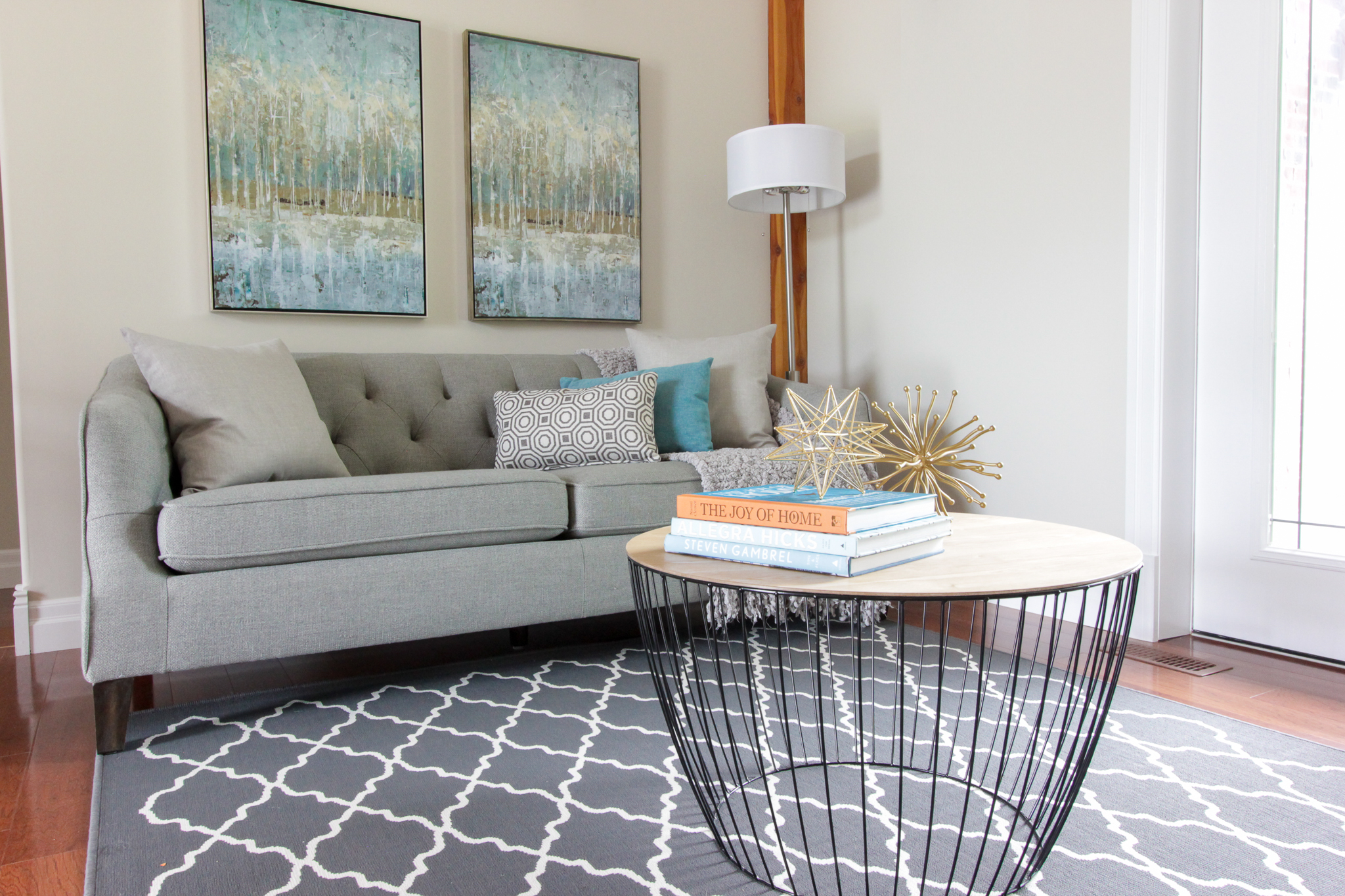 Home Staging provided by New Leaf Decor of living room in Essa- Modern pieces mixed in with colourful art and accents.