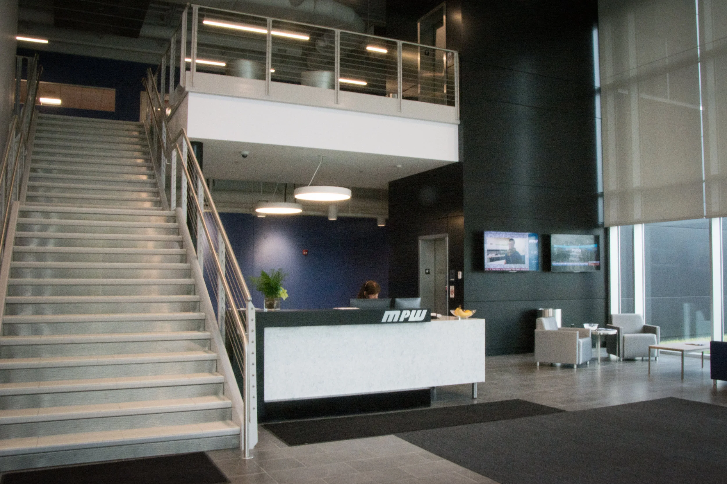 Digital signage and a television greet staff and guests in the bright, open lobby.