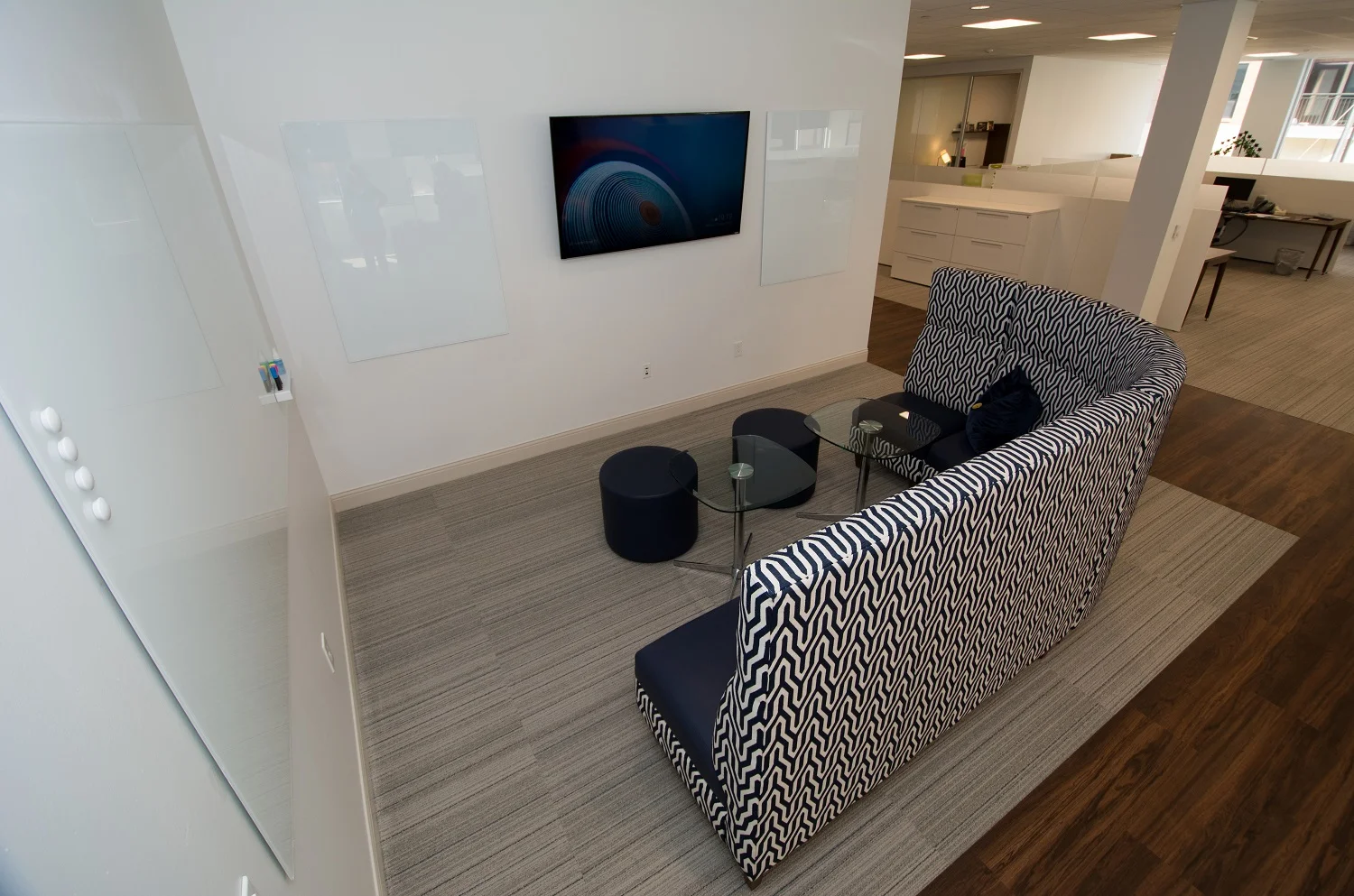 This huddle space, defined by the extended height of the l-shaped couch, offers multiple whiteboards as well as a variety of inputs for display on the 60" TV screen.