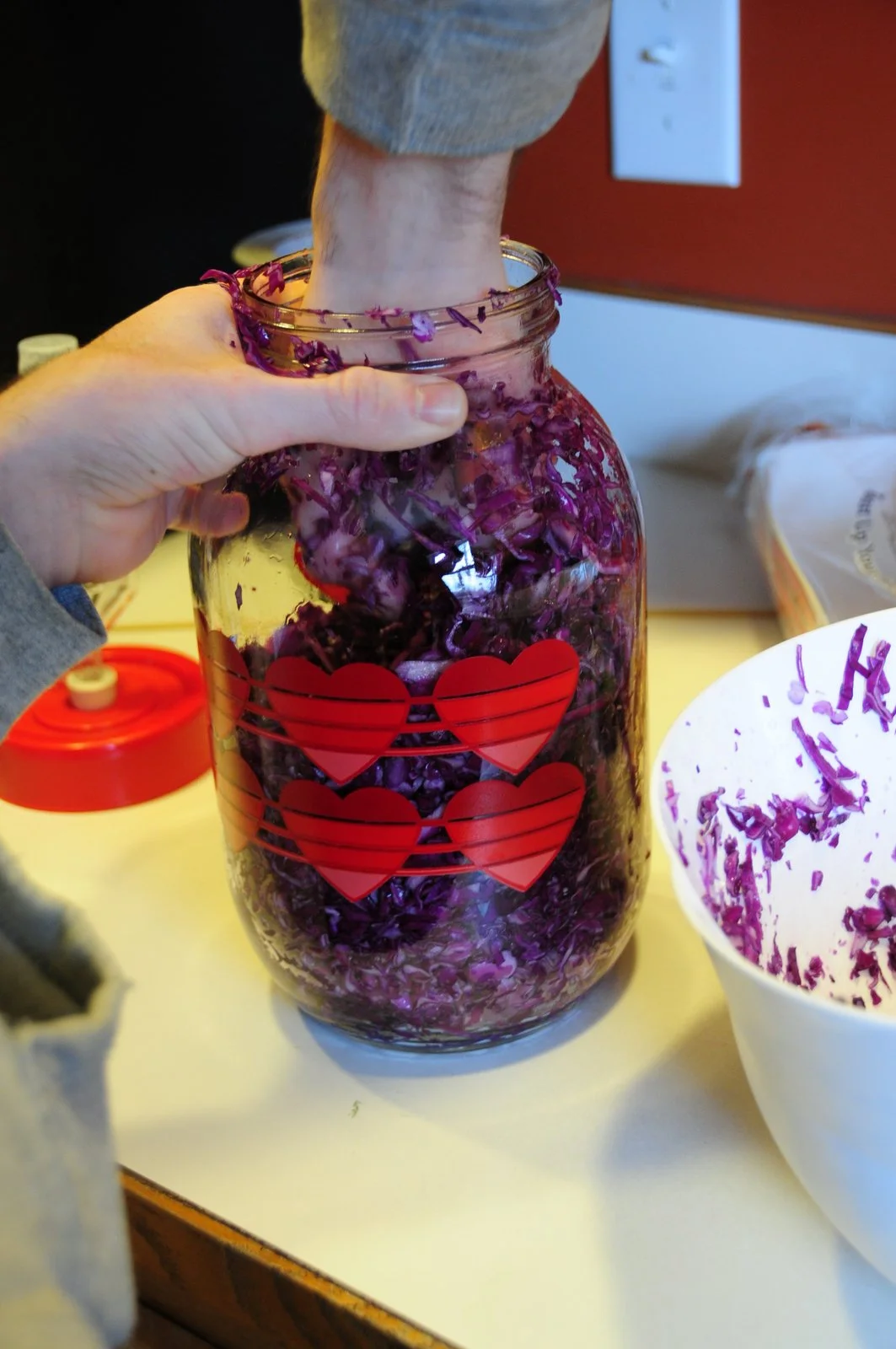 Smash the salty cabbage mixture down into the jar. This is the part where you can find me mercilessly punching the cabbage down into the jar. Punch it! You have to be brutal.