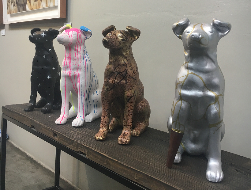 Four Ceramic Dogs Painted with Graffiti Paint for Auction at an Art Gallery