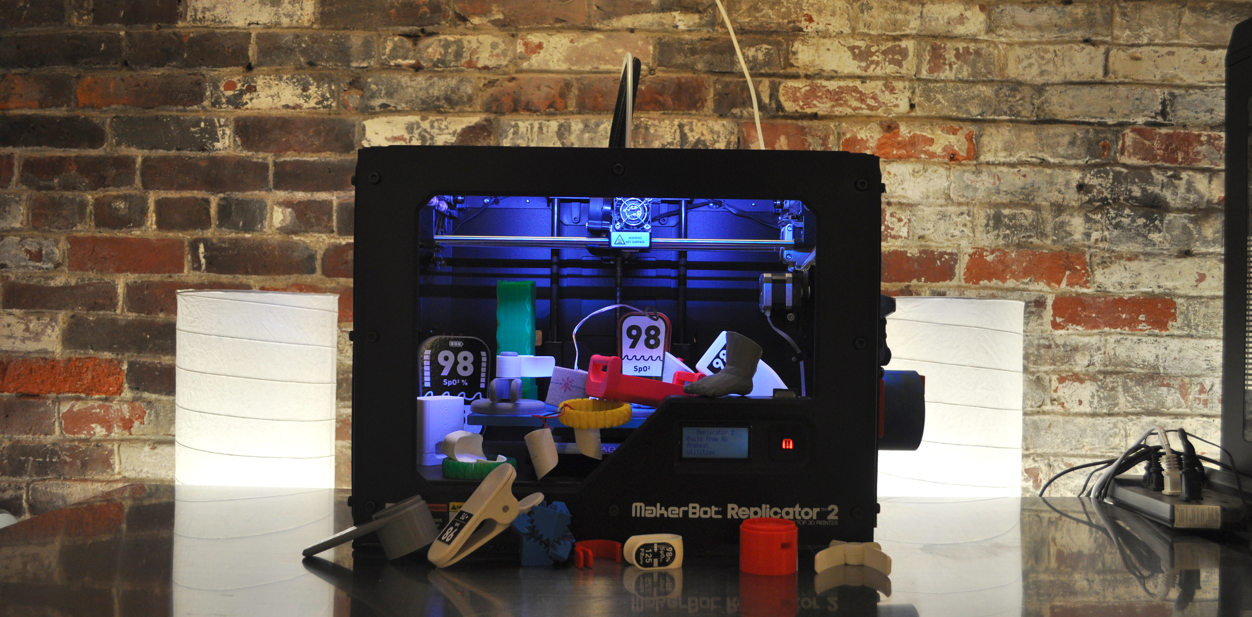 DtM's Makerbot 3D Printer and the pile of prototoypes we've created with it so far.