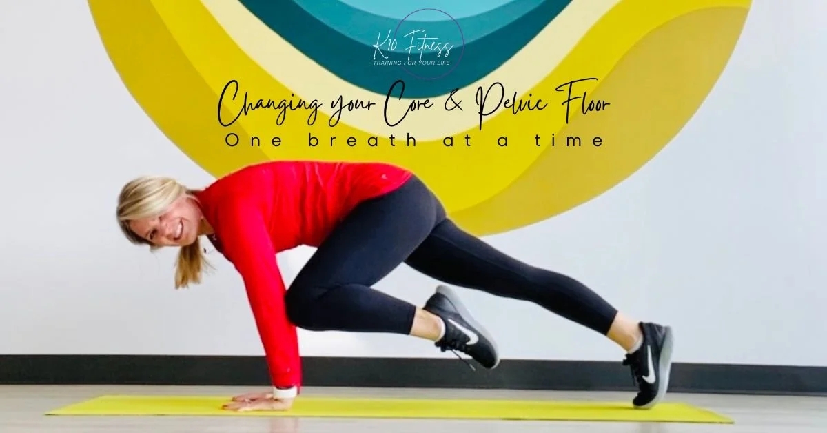 Woman in a red long-sleeve shirt and black leggings doing a plank exercise on a yellow yoga mat in front of a wall with a colorful abstract mural and the text 'Changing your Core & Pelvic Floor, One breath at a time' for Kio Fitness.