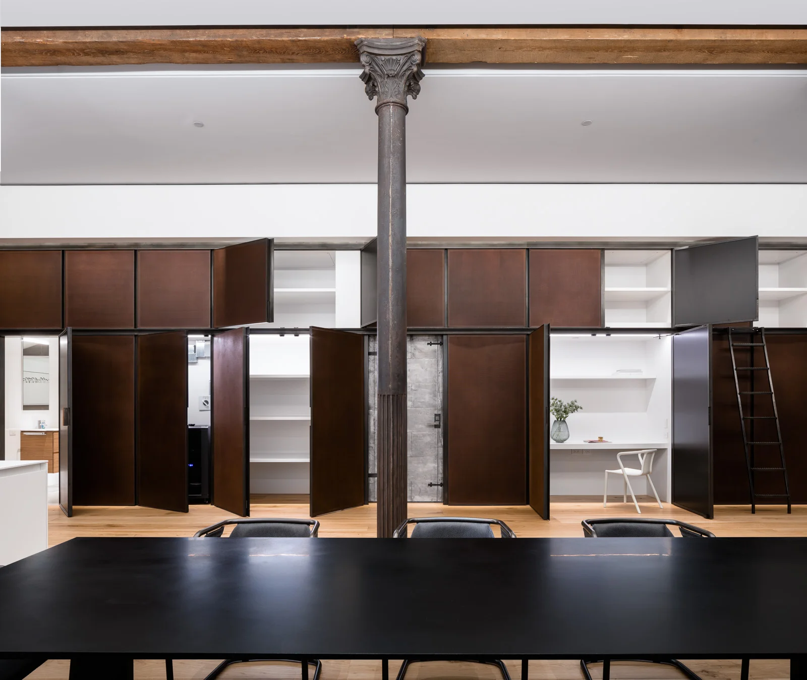 The feature corten steel wall conceals a bathroom, a service entrance, a home office and storage closets. Each are integrated with lighting that is activated when the doors are open.