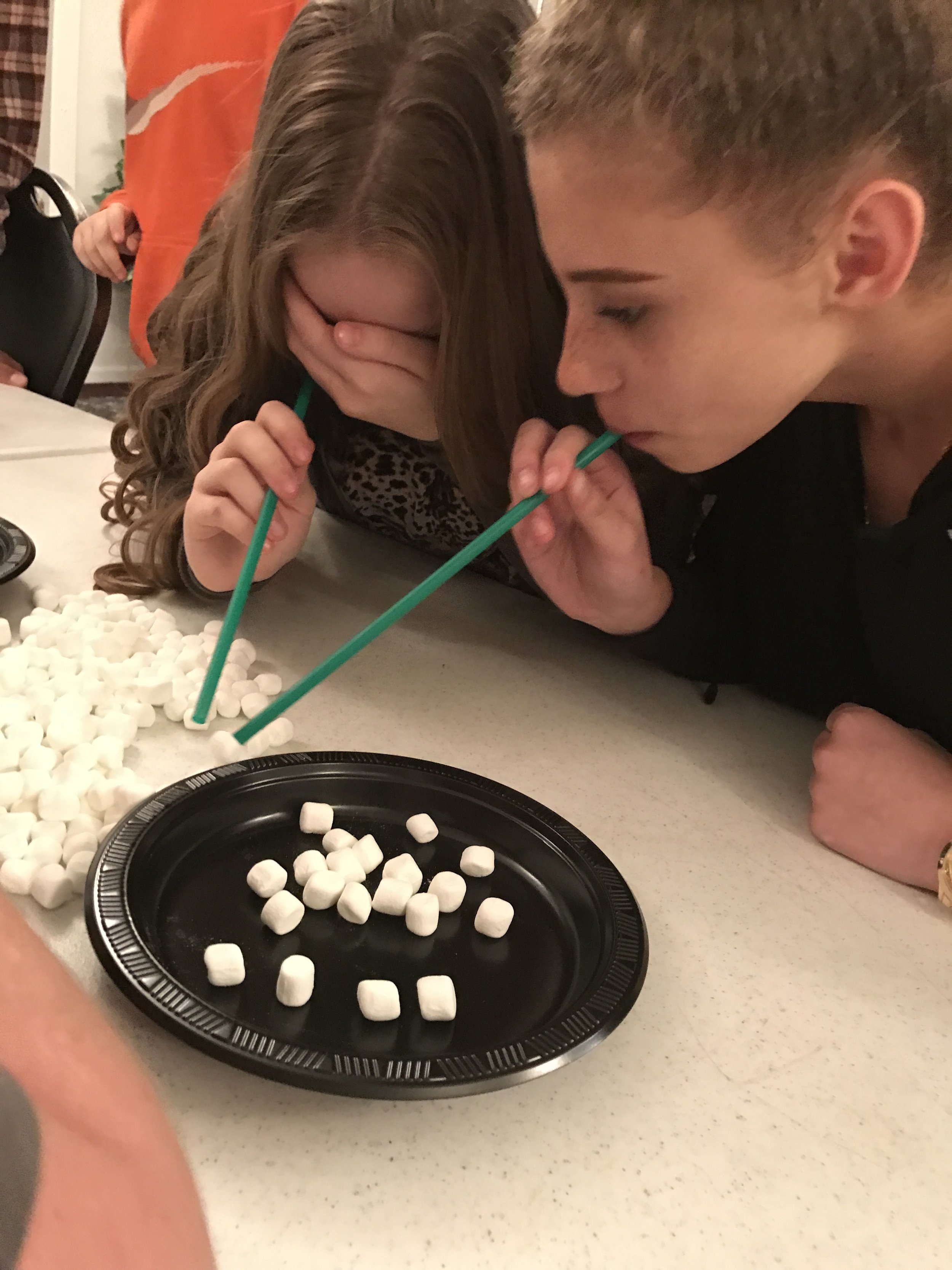 Girls frantically getting as many as they can on their plate in the alloted time.