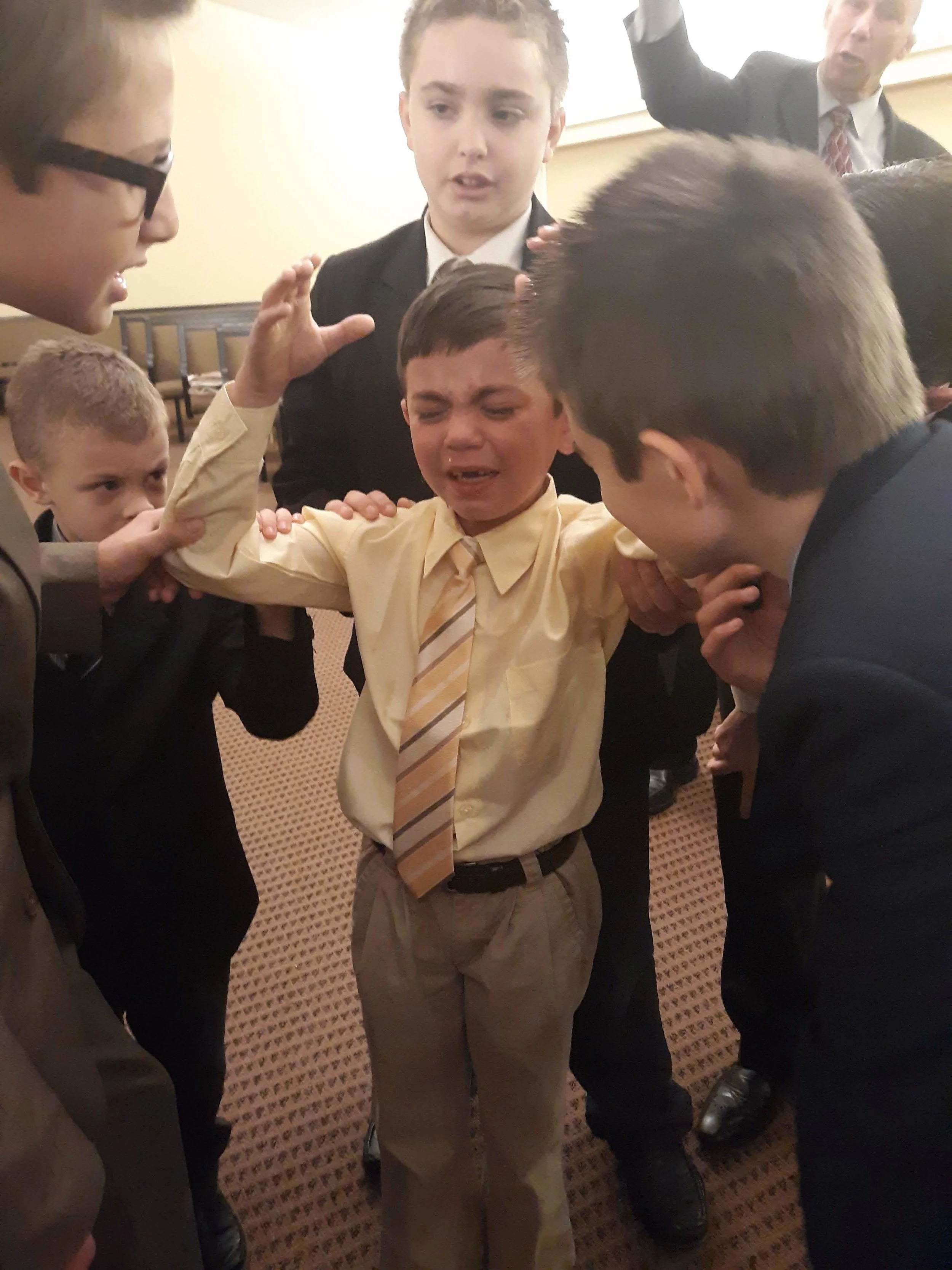 Jared Womack and young boys praying with him to receive the Holy Ghost