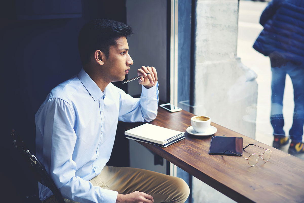 High school student brainstorms their Common App essay at a coffee shop