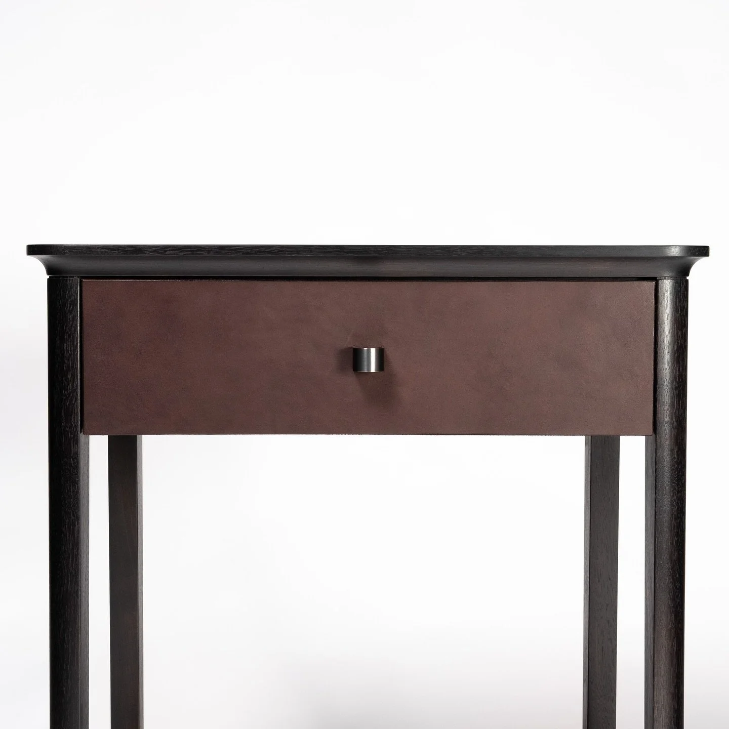 Basin details. The rounded profile of the leg perfectly meets a cove on the underside of the top. The shadow line of the drawer continues around to accent the transition. 

Custom side table in oxidized walnut with a leather drawer front for @thegugg