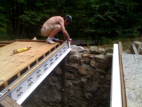 Derek Wilson attaches nailing surface to living room roof beam.