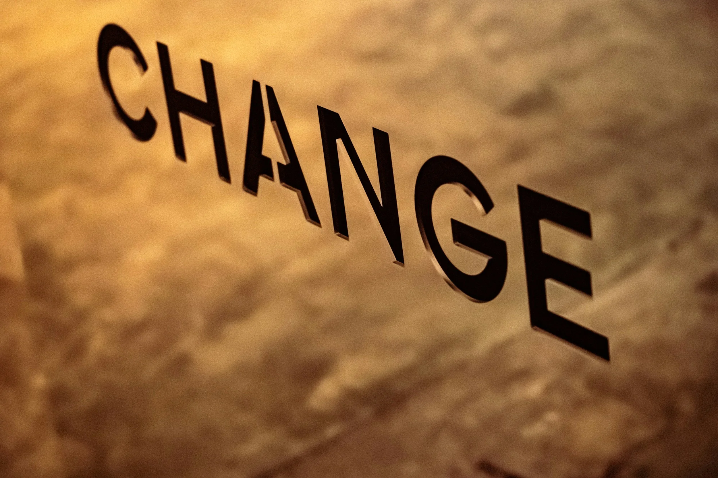 warm gold light behind outline of the word "change"