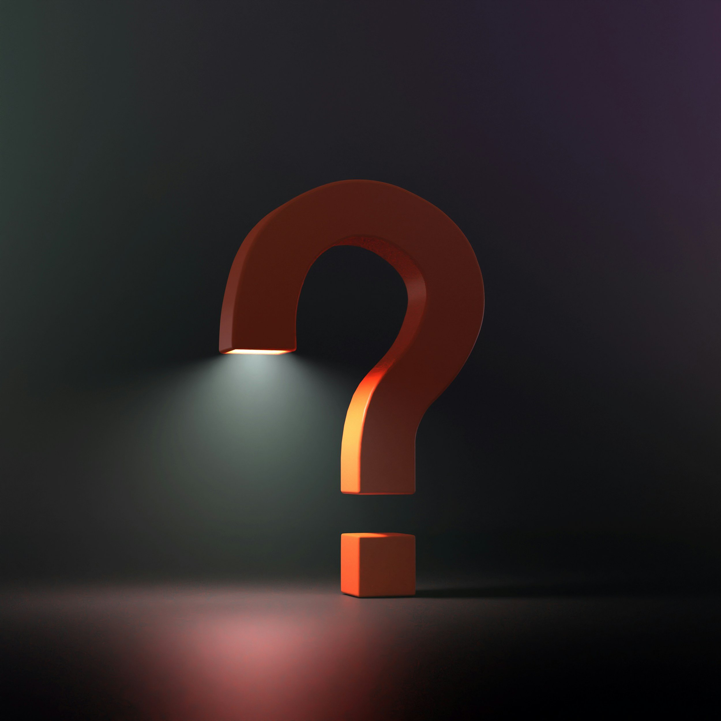 image of an orange question mark in a dark room illuminated by the light at the end of the question mark