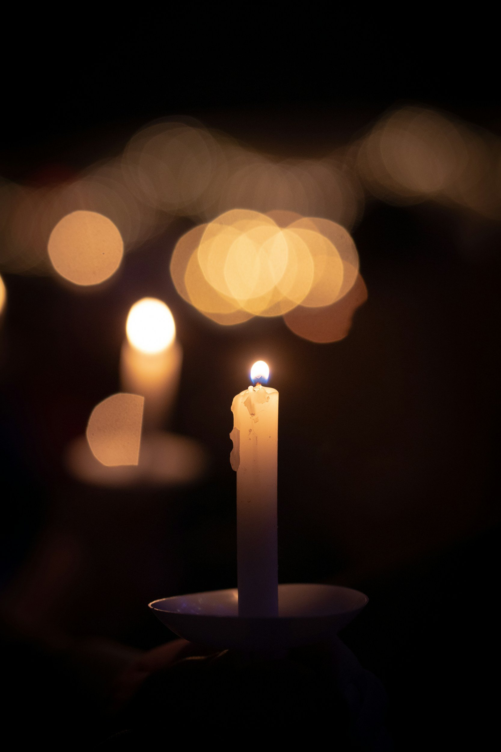 lit candle being held in the dark